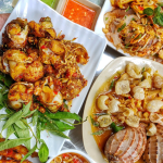 A spread of different snail dishes served alongside grilled seafood at Ốc Thảo.