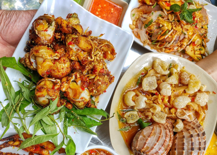 A spread of different snail dishes served alongside grilled seafood at Ốc Thảo.