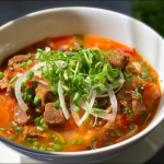 Beef brisket and red wine broth simmering in a pot for phở bò sốt vang.