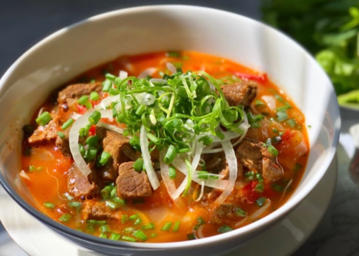 Beef brisket and red wine broth simmering in a pot for phở bò sốt vang.