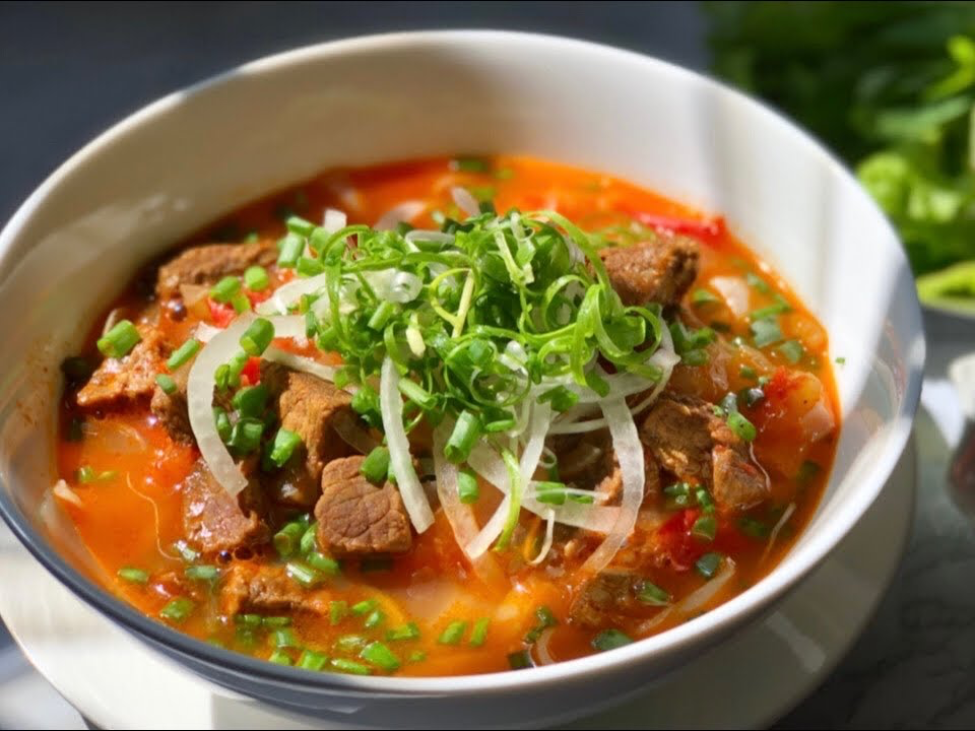 Beef brisket and red wine broth simmering in a pot for phở bò sốt vang 