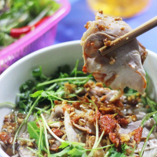 A colorful bowl of sour noodles from Lạng Sơn, featuring rice noodles, shredded chicken, and fresh herbs.