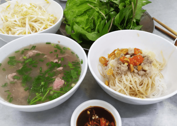 Two bowls of pho—one with noodles, the other with broth and beef meatballs.