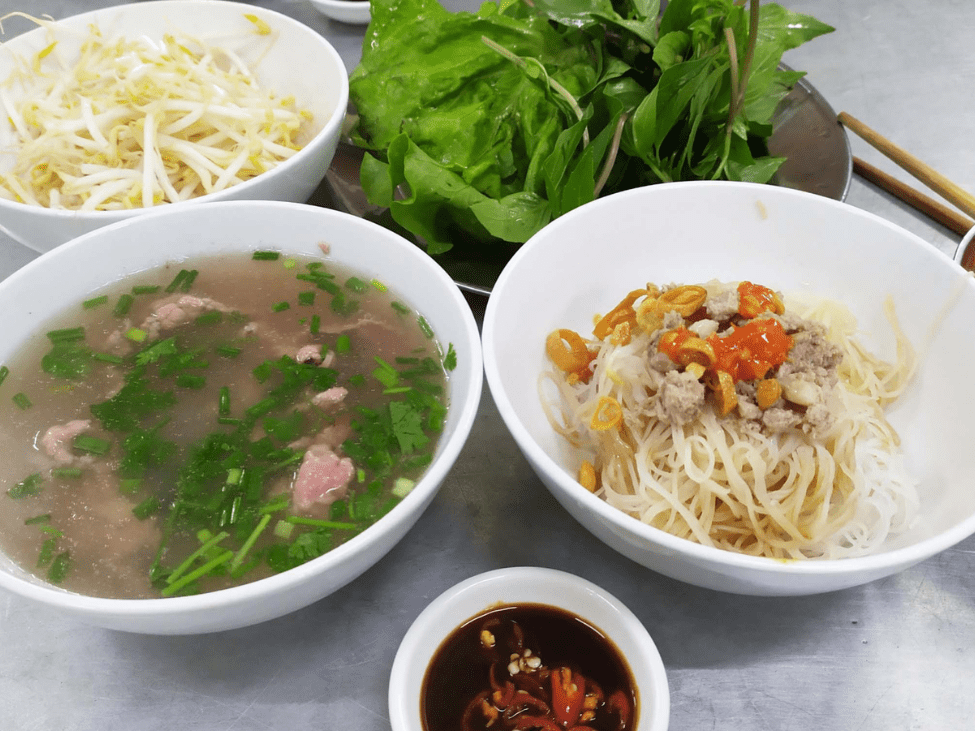 Two bowls of pho—one with noodles, the other with broth and beef meatballs.