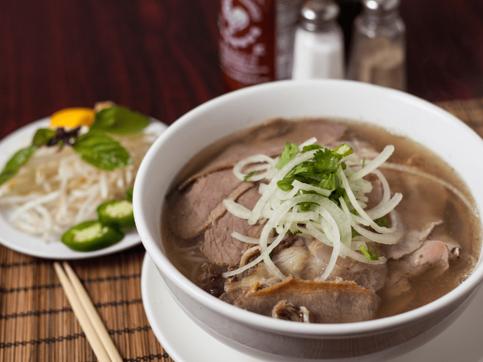 A delicious bowl of Pho Hien's pho with sliced beef and fresh herbs.