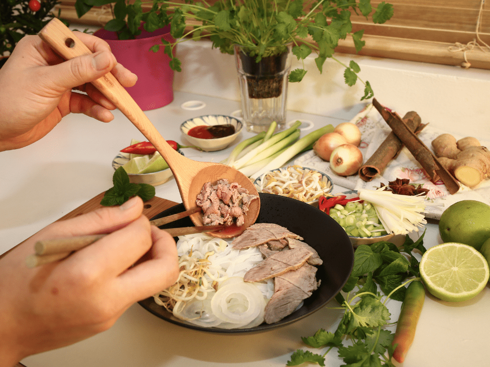 Close-up of pho ingredients: rice noodles, fresh herbs, and aromatic spices.