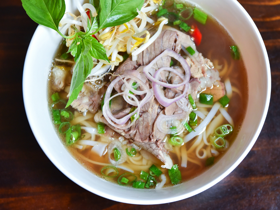 Phở Nhớ’s clear broth pho topped with tender slices of beef and fresh herbs.