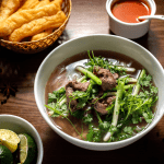 A bowl of Pho Bo from Pho Thin in Hanoi with thinly sliced beef and clear broth.