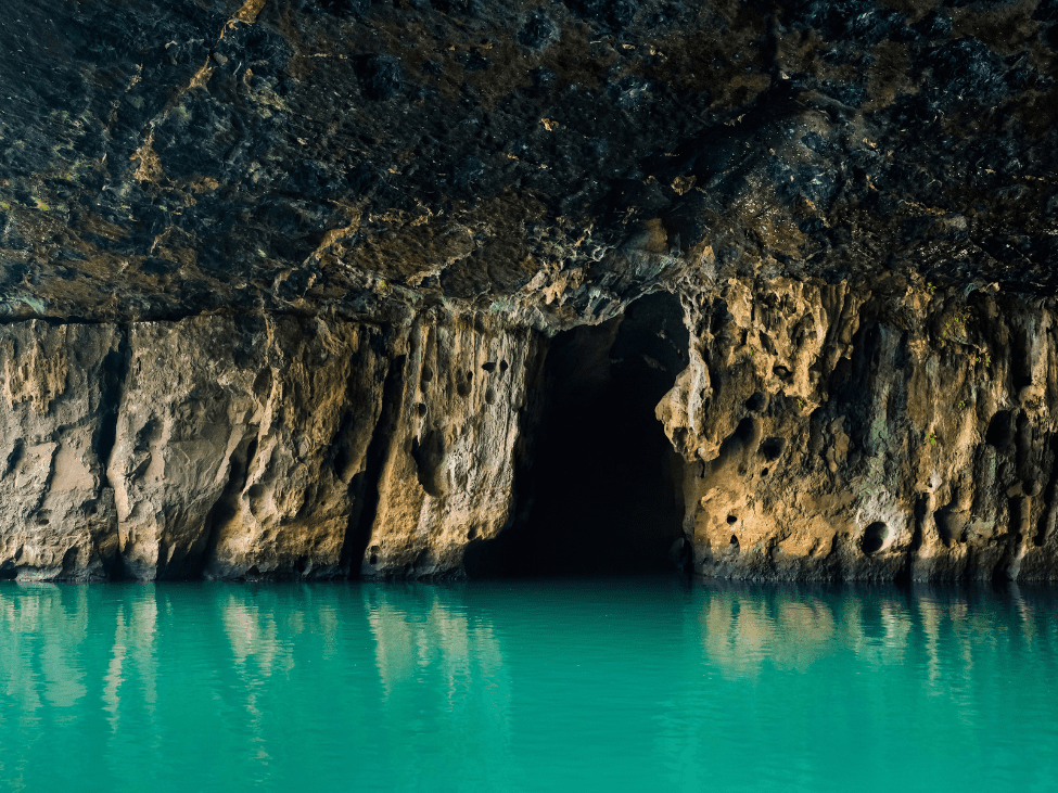 Entrance to the Phong Nha Cave with a boat approaching the cave mouth.