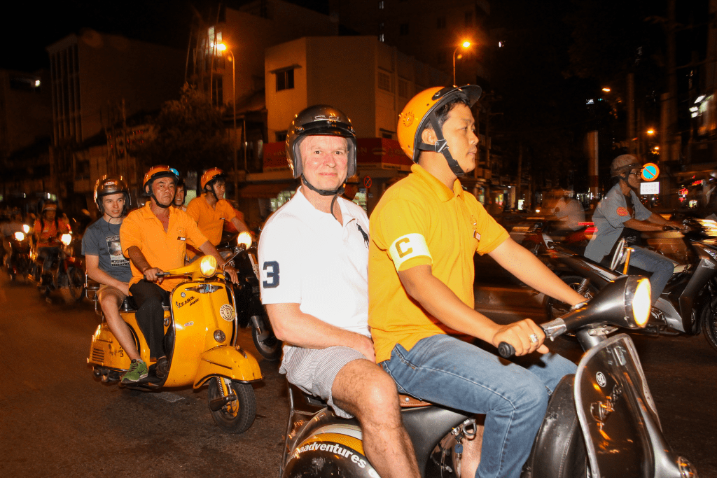 Family exploring Saigon’s vibrant markets on a Vespa, led by a local guide.