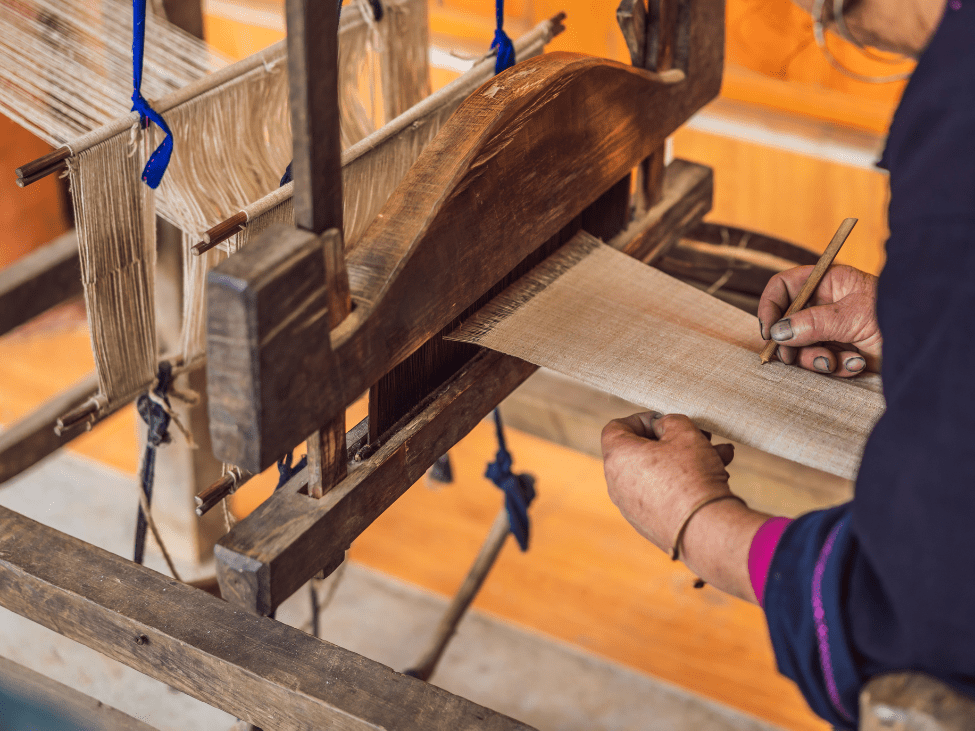 A loom in Hoi An’s Silk Village, with colorful silk threads being woven into intricate patterns.