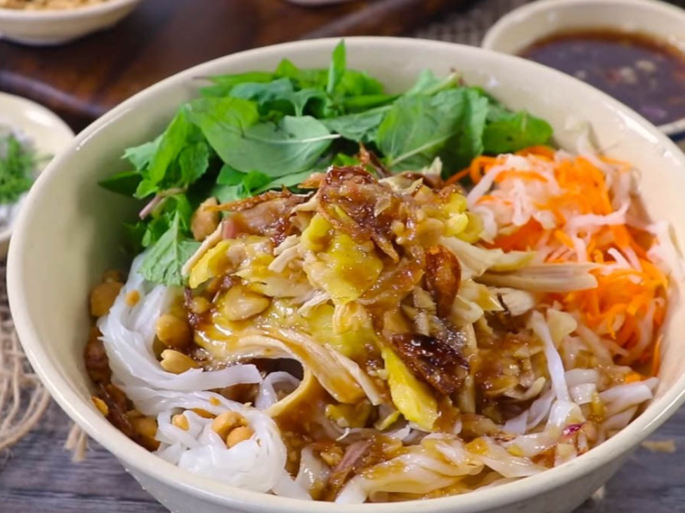 Tangy vinegar sauce being poured over a bowl of sour noodles from Lạng Sơn.