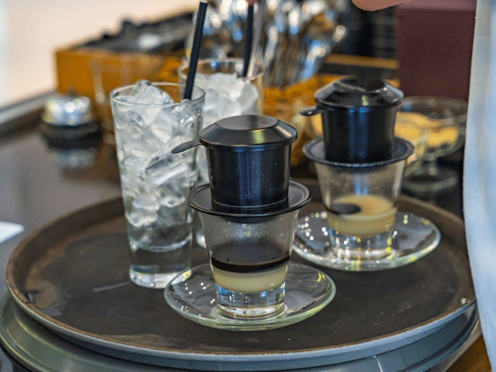 Traditional Vietnamese phin coffee filter dripping into a glass.