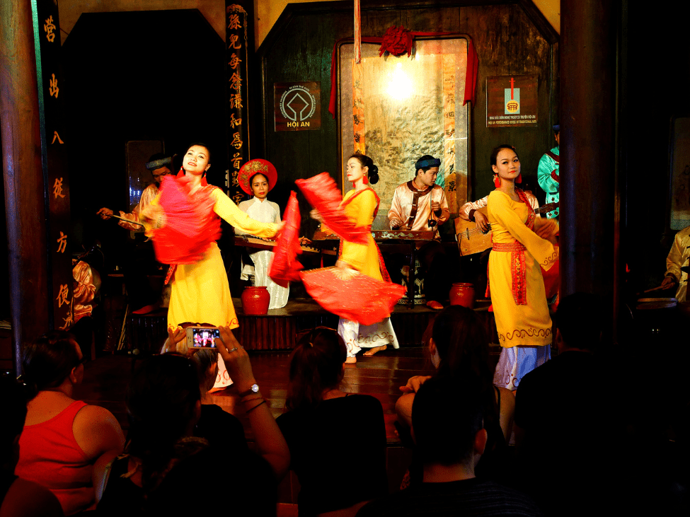 Vietnamese dancers perform a traditional fan dance during a cultural event.