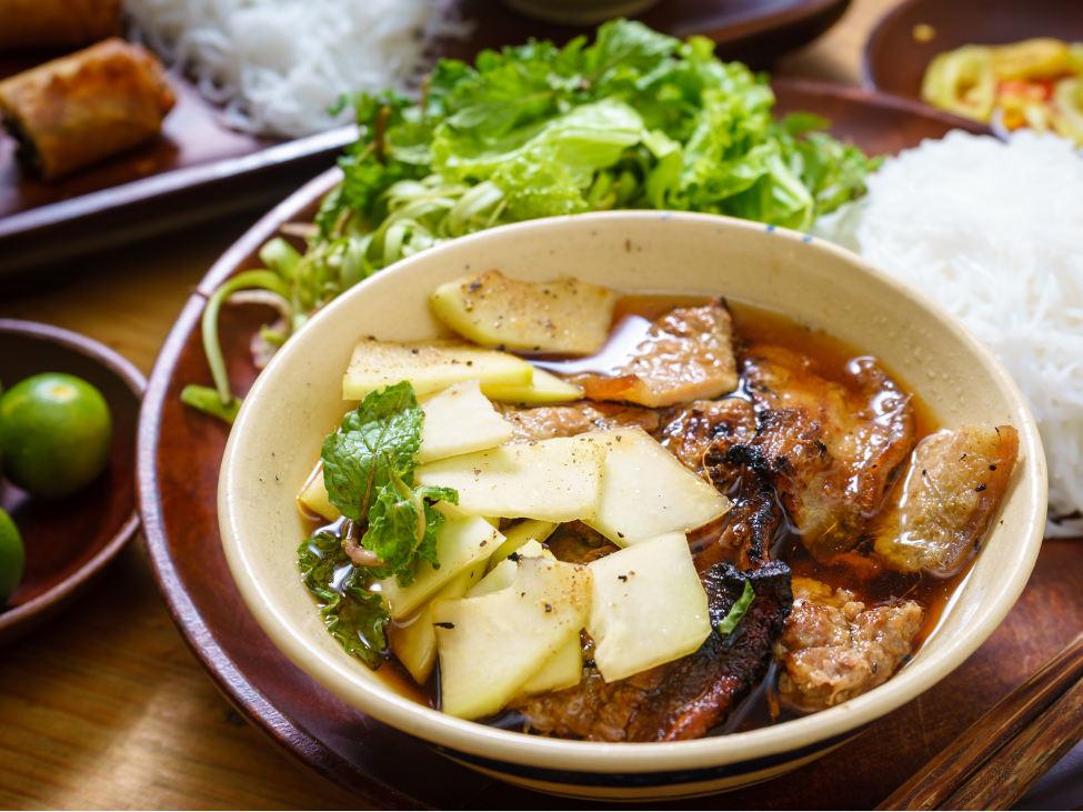 Bowl of bun cha with grilled pork and fresh herbs in Hanoi.