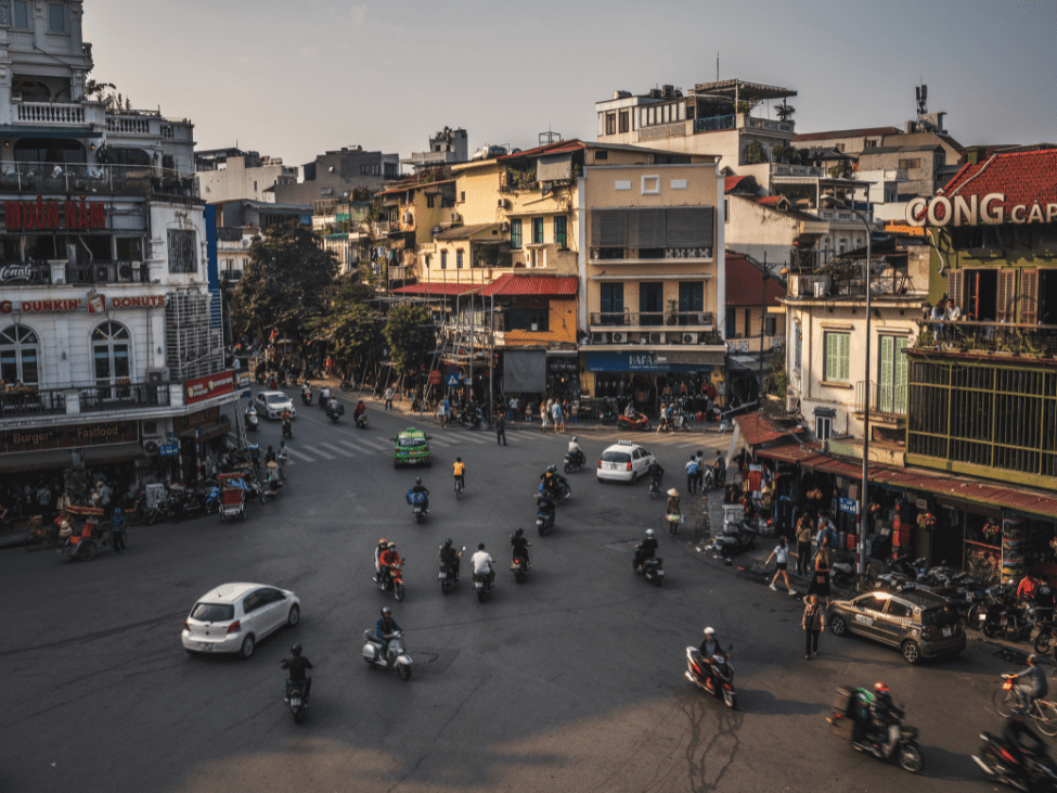 A quiet Hanoi street with colonial-style buildings and parked motorbikes.