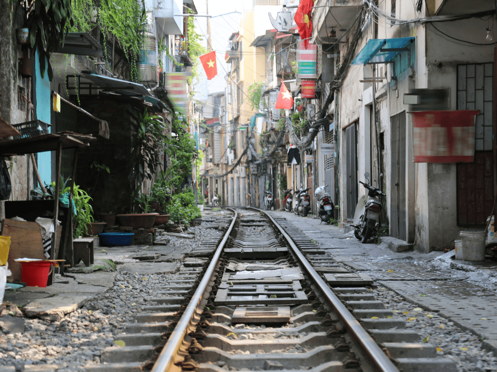 Historic railway tracks running through a bustling Hanoi neighborhood.