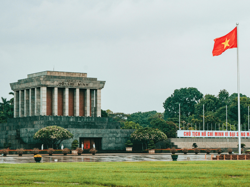 Visitors walking respectfully towards the entrance of the Ho Chi Minh Mausoleum.