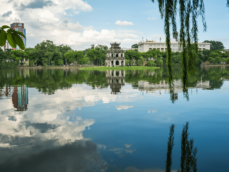 Sunrise over Hoan Kiem Lake with Turtle Tower bathed in golden light.