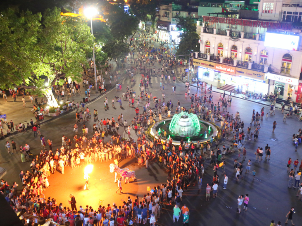 Street performers entertaining crowds on the walking street around Hoan Kiem Lake.