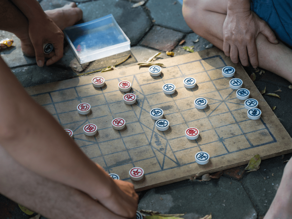 Elderly locals playing chess by the banks of Hoan Kiem Lake.