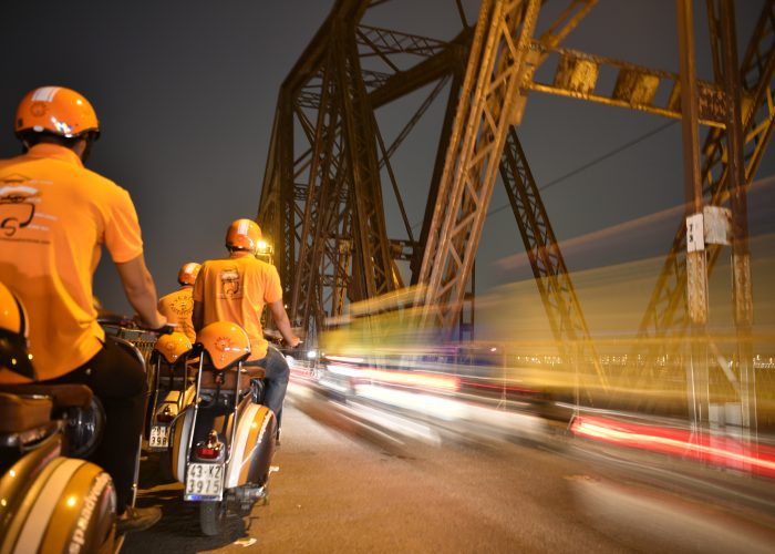 Long Bien Bridge bathed in golden sunset hues, highlighting its iconic architecture.