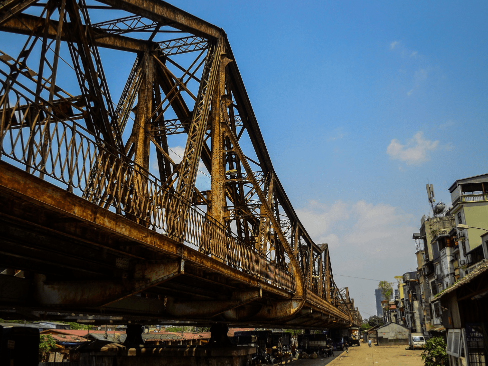 Long Bien Bridge stretching across the Red River in Hanoi, framed by historical significance.