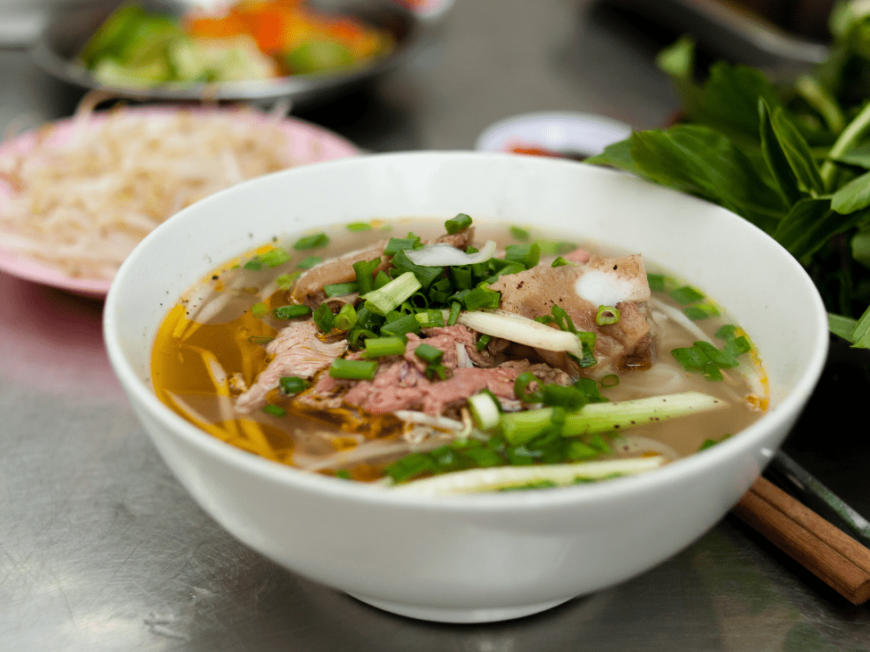 Close-up of steaming bowl of pho from a Hanoi street vendor.