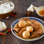 A bowl of braised pork and eggs in caramelized sauce.