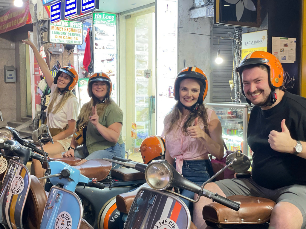 Tourists on vintage Vespas exploring Hanoi Old Quarter