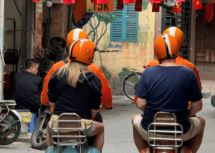 Vespa rider exploring Hanoi’s Old Quarter at sunrise.