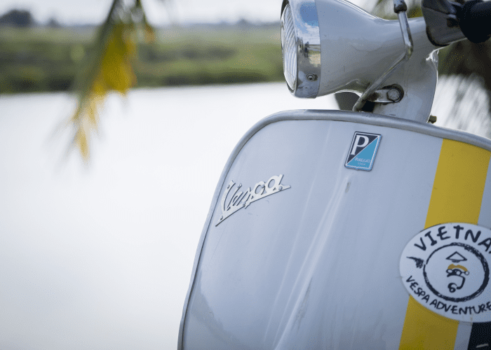 A Vespa scooter parked on a street in Vietnam, ready for an adventure.