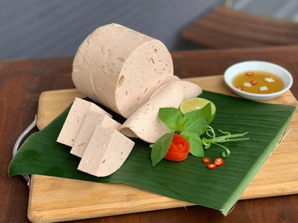 Vietnamese pork sausage slices served alongside fresh herbs.