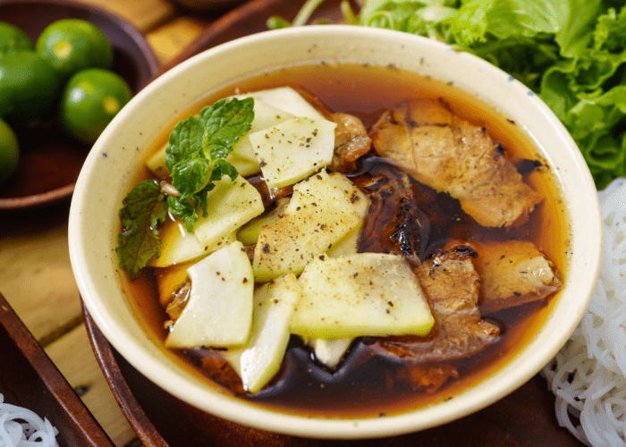 A bowl of Bun Cha with grilled pork, noodles, and herbs.