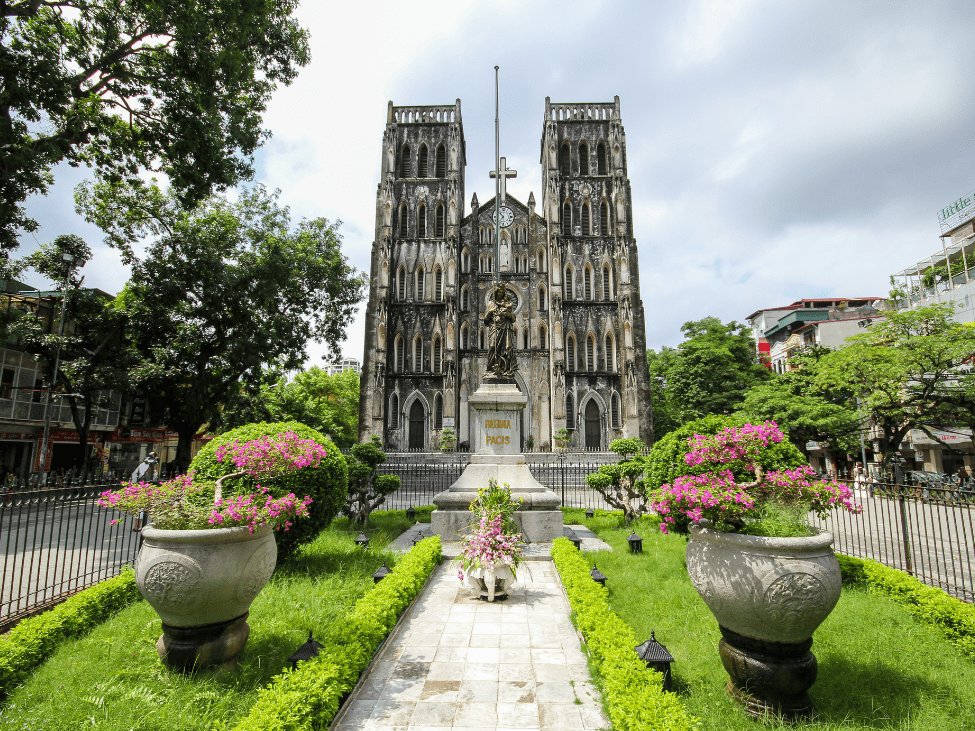 Neo-Gothic St Joseph’s Cathedral surrounded by lush greenery in Hanoi.