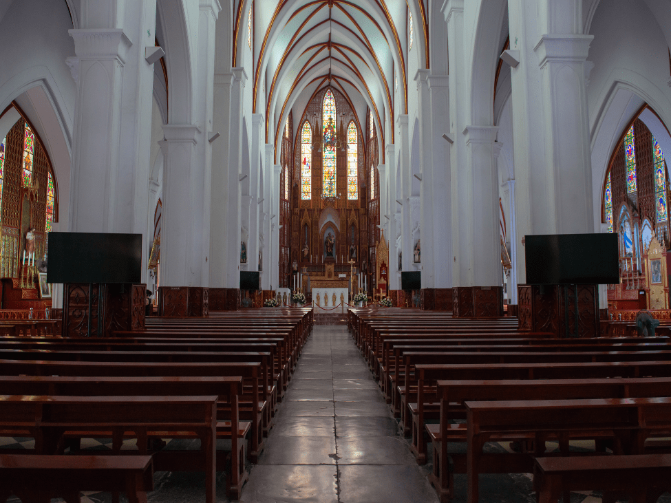 Interior view of St Joseph’s Cathedral featuring stained-glass windows and ornate altar.