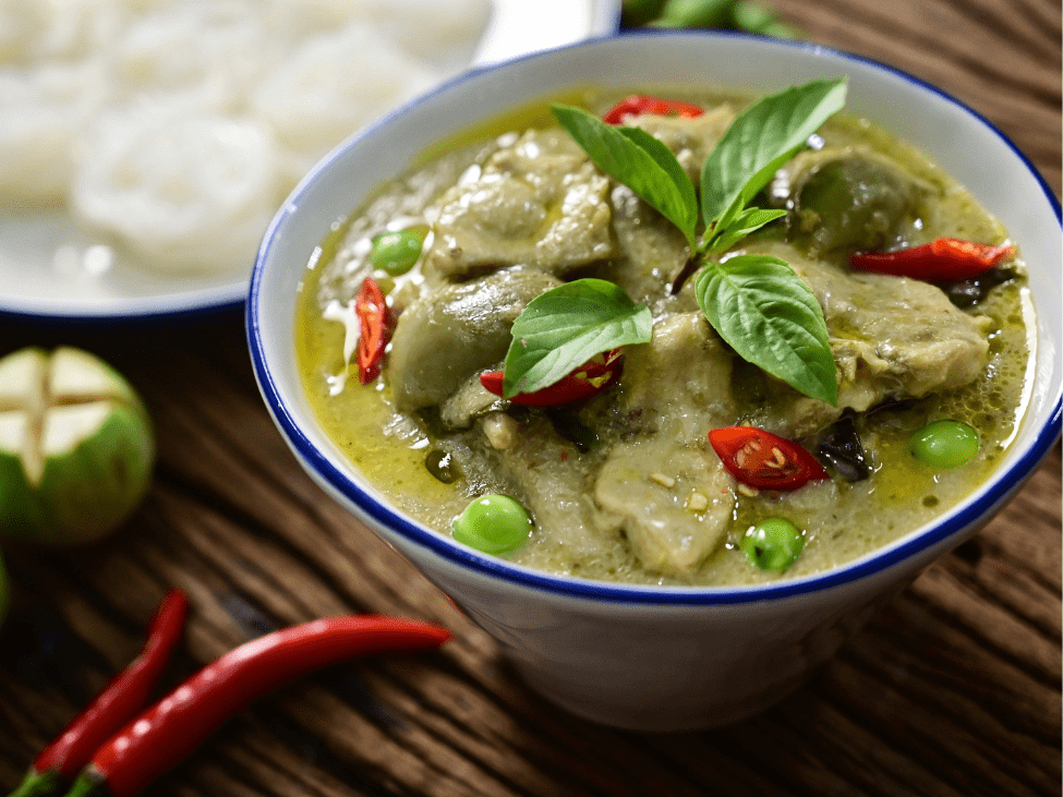 Thai green curry served with jasmine rice and garnished with fresh basil.