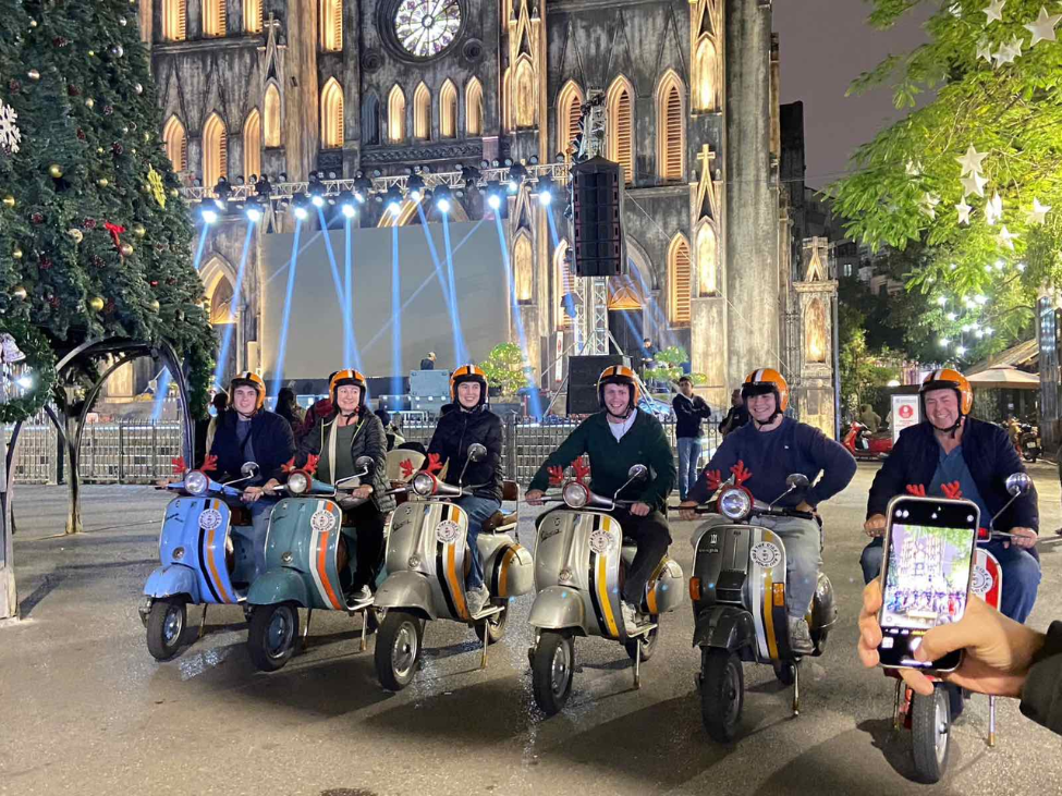 A group of travelers enjoying a Vespa tour in Vietnam’s scenic countryside.